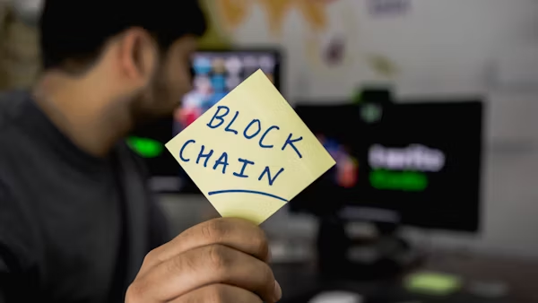 image of a man holding a paper with blockchain